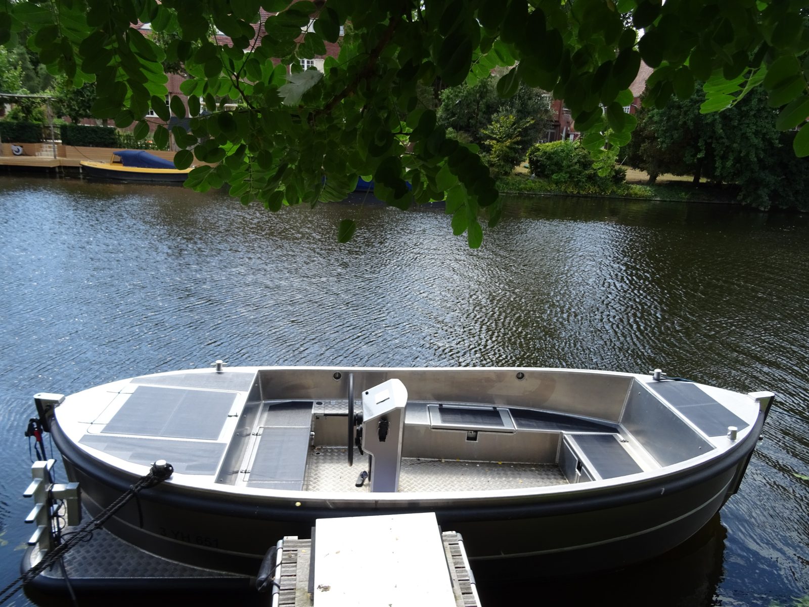 Omgebouwde aluminium sloep met zonnepanelen aan de kade